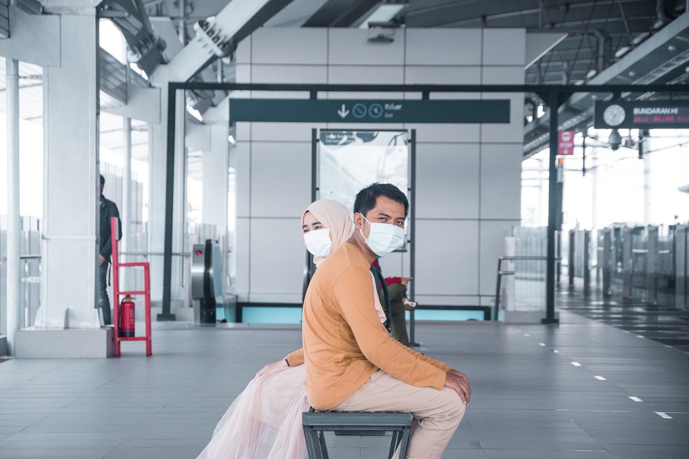 masked couple seated at airport