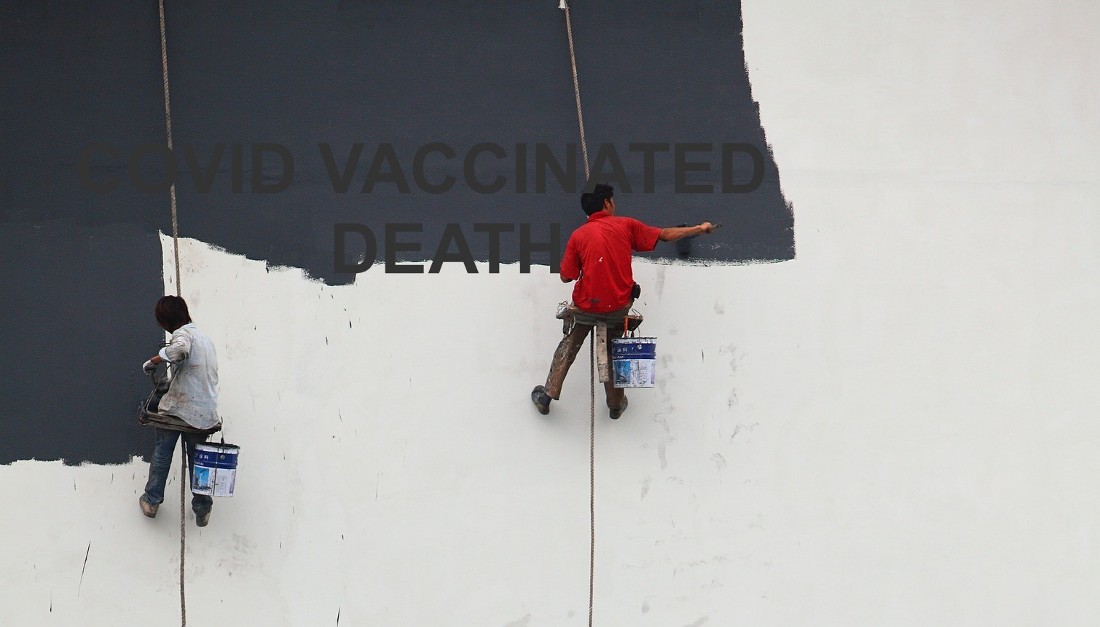 two men suspended and painting a wall