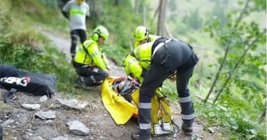 1 person in forest observing 3 rescue workers dealing with deceased person