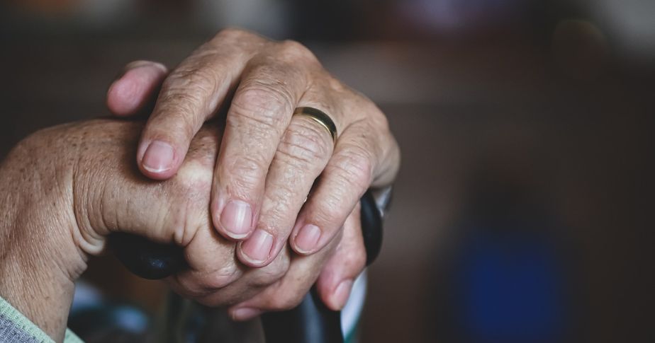 elderly hands with walking stick