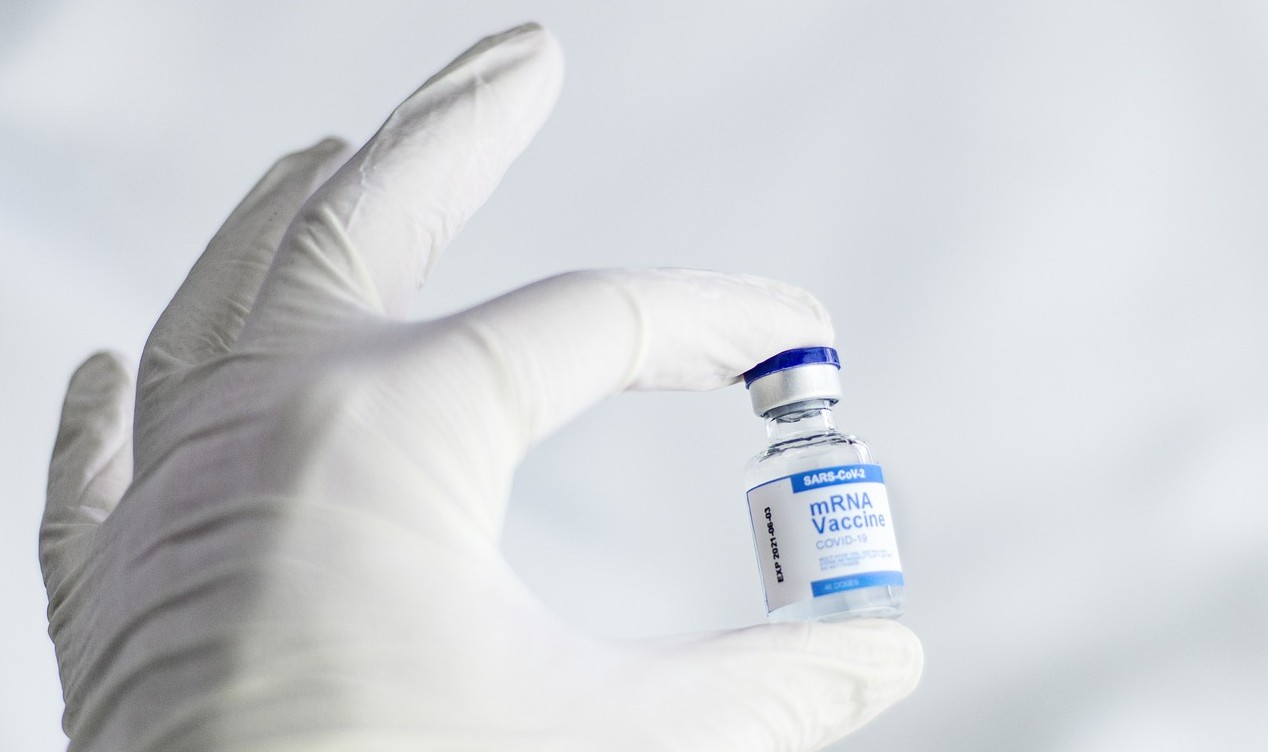 gloved hand holding mrna vaccine vial2